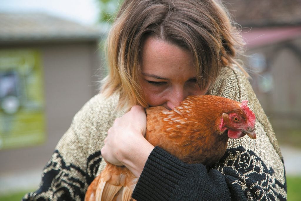 Femme câlinant une poule